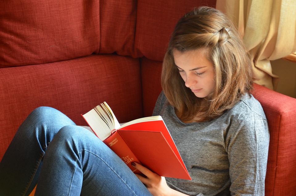 teenage girl reading on sofa